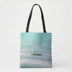 White starfish on sand underwater in the morning tote bag