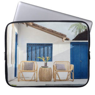 Wicker table and two chairs near swimming pool laptop sleeve