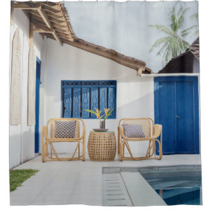 Wicker table and two chairs near swimming pool shower curtain