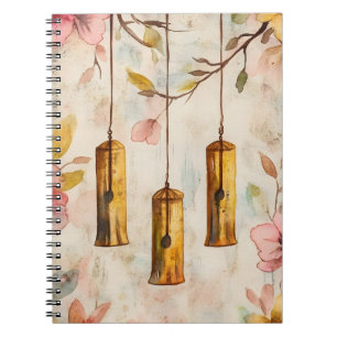 Wind chimes suspended from a flowering branch.  notebook