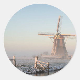 Windmill in the snow at sunrise round sticker