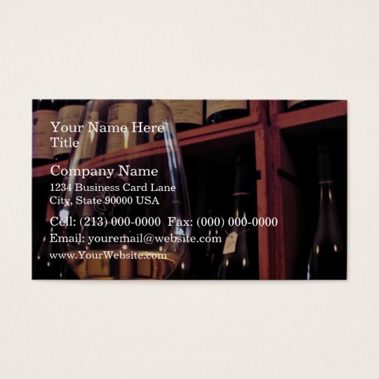 Wine glass with bottles in background business card
