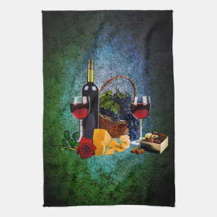 Wine glasses, bottle, grapes, cheese, chocolates tea towel