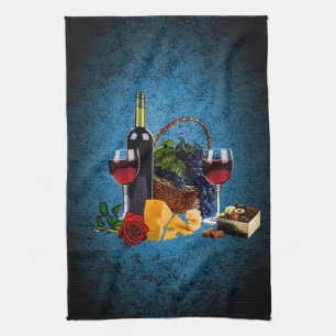 Wine glasses, bottle, grapes, cheese, chocolates tea towel