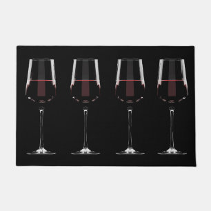 Wine glasses with red wine on black doormat