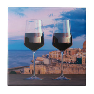 Wine glasses with view of sunset over Valletta Tile