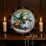 Winter Fun Snowman Sledding Robin  Large Clock<br><div class="desc">Embrace "Winter Fun" with this cheerful round sign featuring a rosy-cheeked snowman wearing a green knit hat, scarf, and mittens. He's happily sledding down a snowy hill with a little robin bird passenger. This playful scene is set against a backdrop of snowy pines and falling snowflakes, making it a cute...</div>