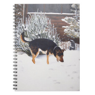 Winter snow scene with cute black and tan dog notebook