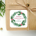 Winter Sprigs Wreath Merry Christmas Watercolor Square Sticker<br><div class="desc">This personalised holiday sticker features a watercolor wreath of green and red winter greenery,  including evergreen pine sprigs and holly leaves and berries. The words "Merry Christmas" appear in red serif font. Personalise the design with your family name below in green italics.</div>