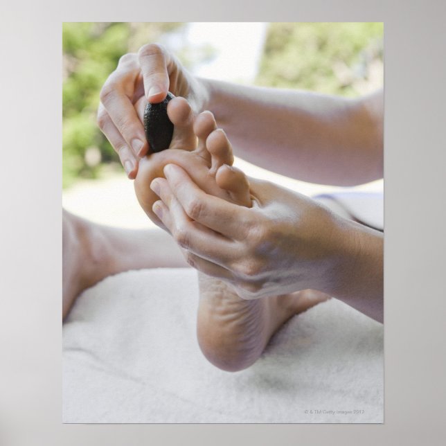 Woman getting foot massage with hot stone poster (Front)