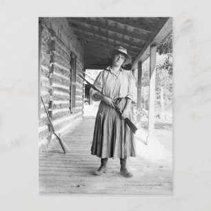 Woman holding a rifle on a porch postcard