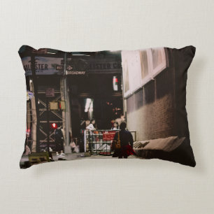 WOMAN IN BLACK AND RED DRESS WALKING BESIDE BROWN  DECORATIVE CUSHION