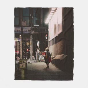 WOMAN IN BLACK AND RED DRESS WALKING BESIDE BROWN  FLEECE BLANKET