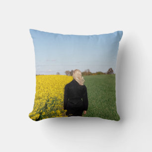 Woman in black coat standing on green grass field  cushion