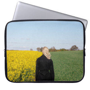 Woman in black coat standing on green grass field laptop sleeve