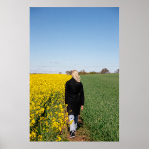 Woman in black coat standing on green grass field poster