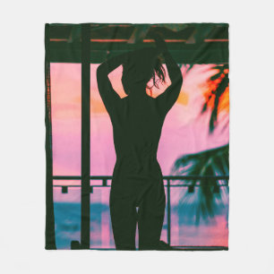 Woman in black tank top and pants standing on blac fleece blanket