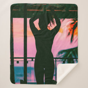 Woman in black tank top and pants standing on blac sherpa blanket