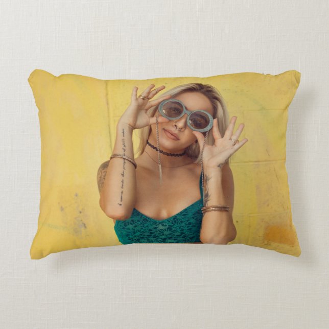 Woman in blue bralette holding sunglasses putting  decorative cushion (Front)