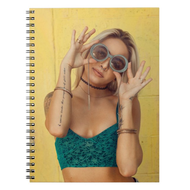 Woman in blue bralette holding sunglasses putting  notebook (Front)