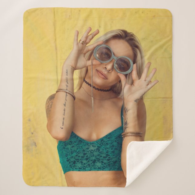 Woman in blue bralette holding sunglasses putting  sherpa blanket (Front)