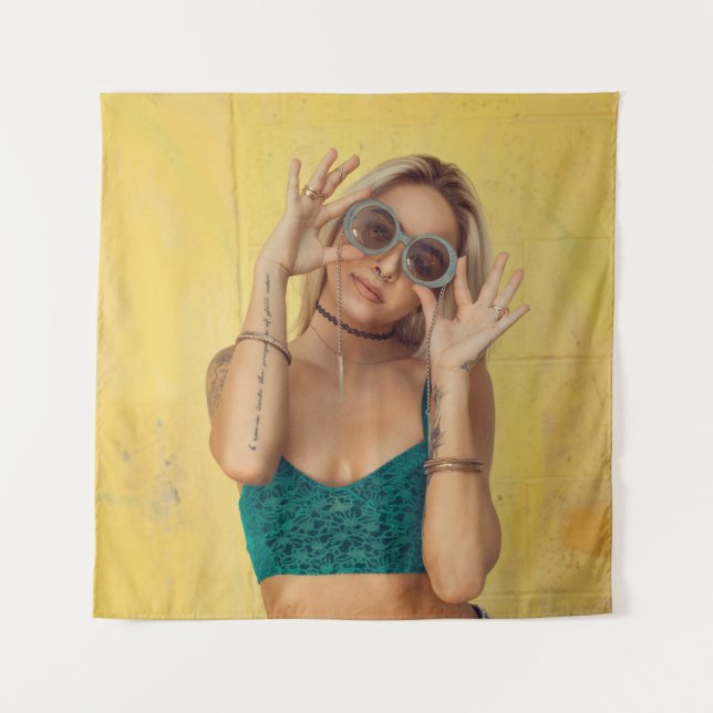Woman in blue bralette holding sunglasses putting  tapestry (Front)