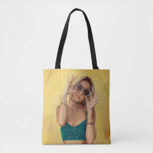 Woman in blue bralette holding sunglasses putting  tote bag