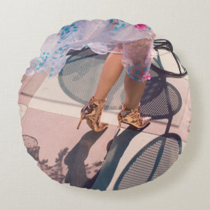 Woman in white pink and green floral skirt and bro round cushion