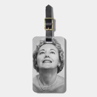 Woman Looking Up Luggage Tag