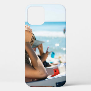Woman lying on sun lounger covering her face with  iPhone 12 case