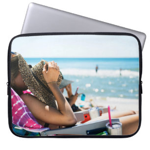 Woman lying on sun lounger covering her face with  laptop sleeve