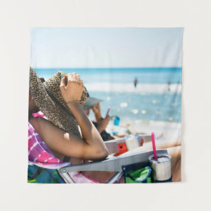 Woman lying on sun lounger covering her face with  tapestry