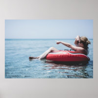 Woman on an inflatable float in the ocean pointing