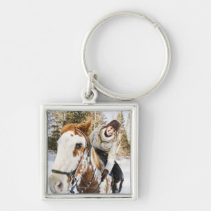 Woman on horse outdoors during winter key ring