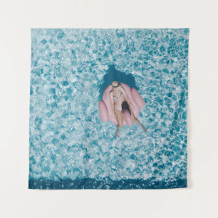 Woman on pink buoy surrounded by body of water in tapestry