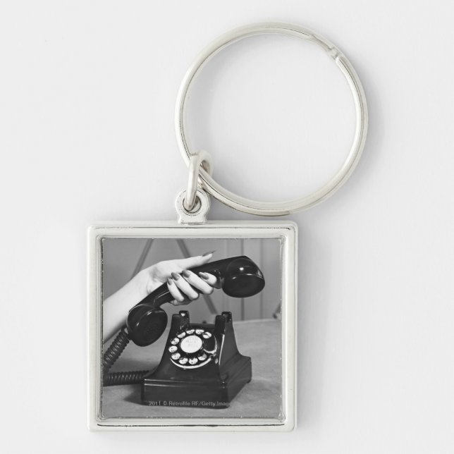 Woman picking up phone close up of hand key ring (Front)