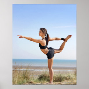 Woman practicing yoga on beach poster
