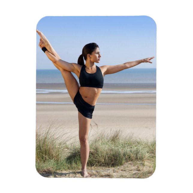 woman practicing yoga on beach wearing magnet (Vertical)
