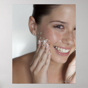 Woman scrubbing sugar on her face poster