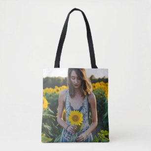 Woman standing at sunflower field tote bag