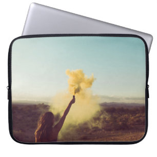 Woman standing on desert holding flare laptop sleeve