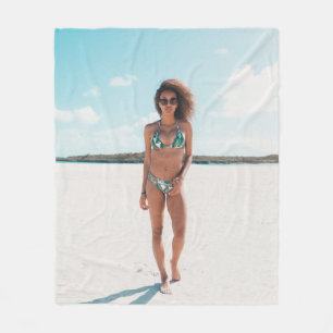 Woman wearing bikini standing on sand fleece blanket
