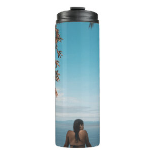 Woman wearing black bikini tap swimming on body of thermal tumbler