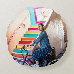 Woman wearing blue denim jacket and shorts riding round cushion