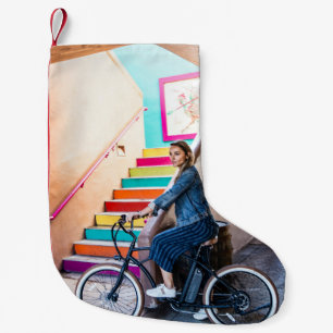 Woman wearing blue denim jacket and shorts riding small christmas stocking