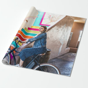 Woman wearing blue denim jacket and shorts riding  wrapping paper