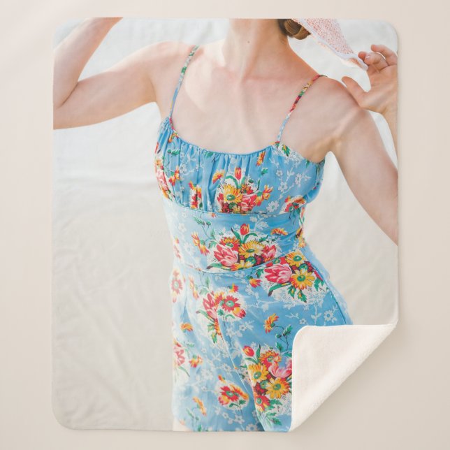 Woman wearing blue floral rompers and brown hat sherpa blanket (Front)
