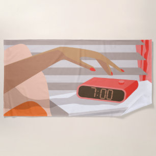 Womans hand pushing on alarm clock snooze button beach towel