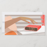 Womans hand pushing on alarm clock snooze button