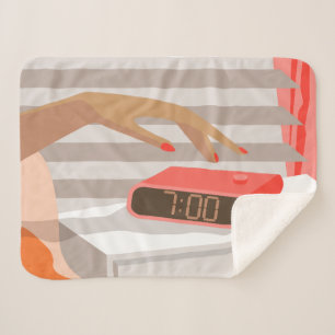 Womans hand pushing on alarm clock snooze button sherpa blanket